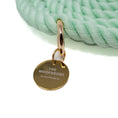 Load image into Gallery viewer, Gold tag with 'The Woofdrobe' branding on a light green rope leash, on a white background
